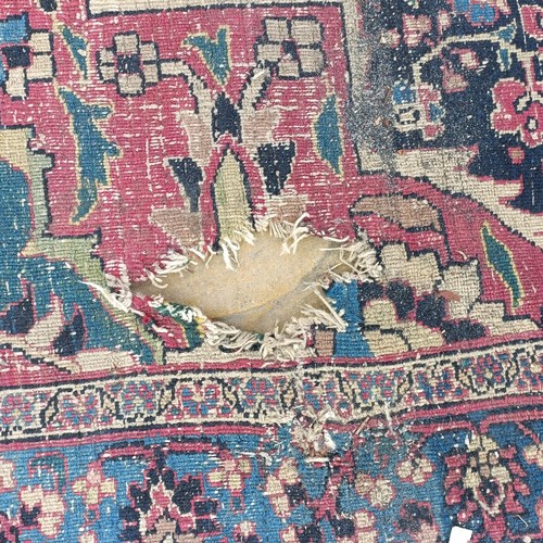 1281 - A large Persian style carpet, heavily worn, 477 cm x 326 cm