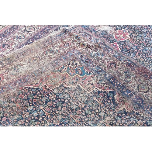 1281 - A large Persian style carpet, heavily worn, 477 cm x 326 cm