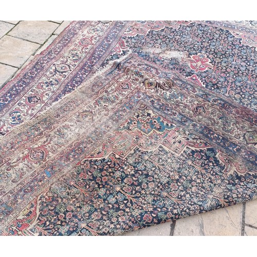 1281 - A large Persian style carpet, heavily worn, 477 cm x 326 cm