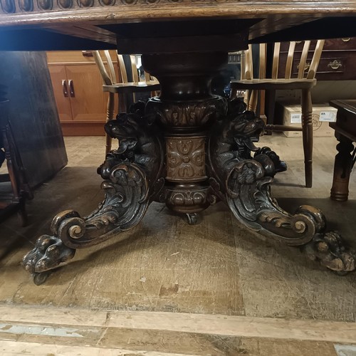 1265 - A late 19th century oak extending dining table, inset a (later) leaf, on a base carved mythical beas... 