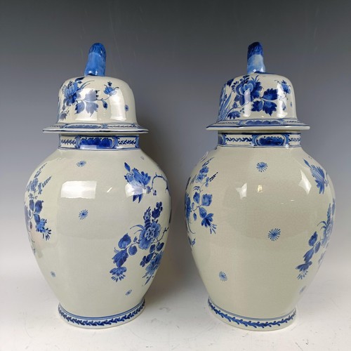 1059 - A near pair of blue and white Delft vases and covers, 55 cm high (2)