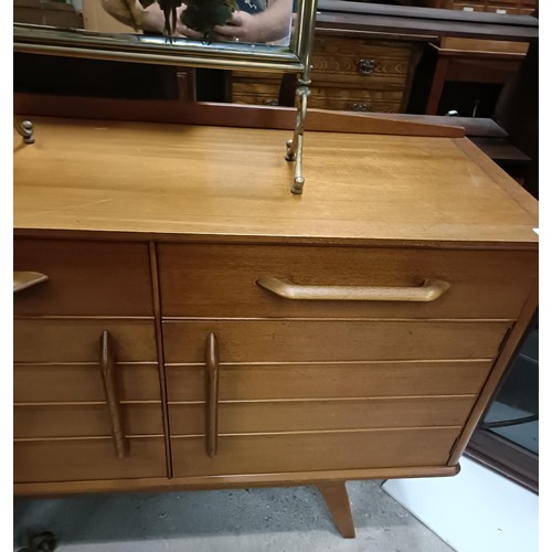 469 - An Ernest Gomme teak sideboard, with two drawers and two cupboard doors, a matching dining table and... 