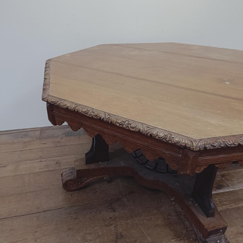 792 - A Victorian carved oak octagonal library table, on a carved column support to a shaped base, 140 cm ... 