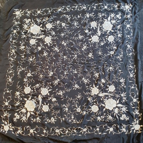 136 - A 1920s white and black silk embroidered shawl, decorated flowers