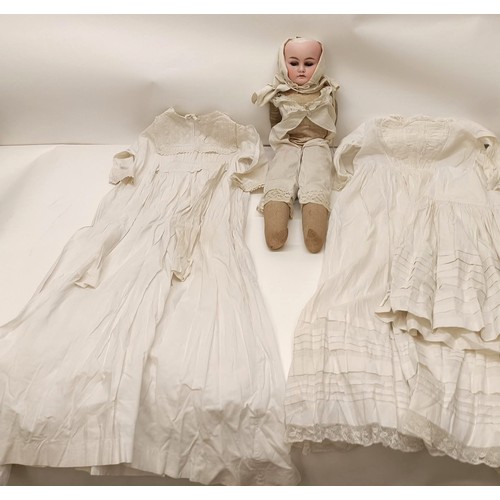 128 - Assorted christening gowns, and a bisque head doll