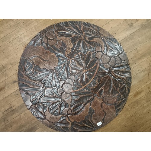 460 - A Liberty style two tier table, carved lillies, 75 cm diameter