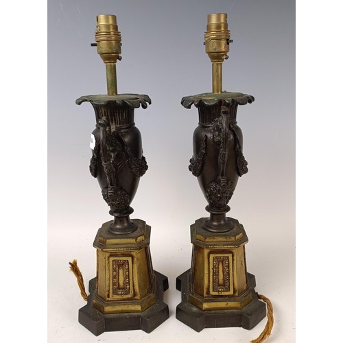 514 - A pair of bronze and gilt bronze lamp bases, in the form of urns, 42 cm high (2)