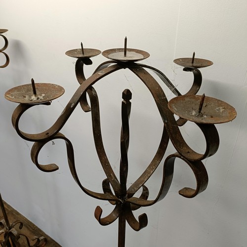 635 - A pair of wrought iron standard pricket candle stands, 164 cm high