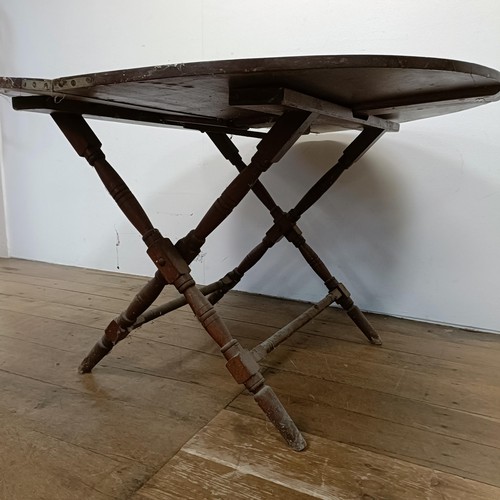 682 - A walnut coaching folding demi-lune table, 105 cm wide