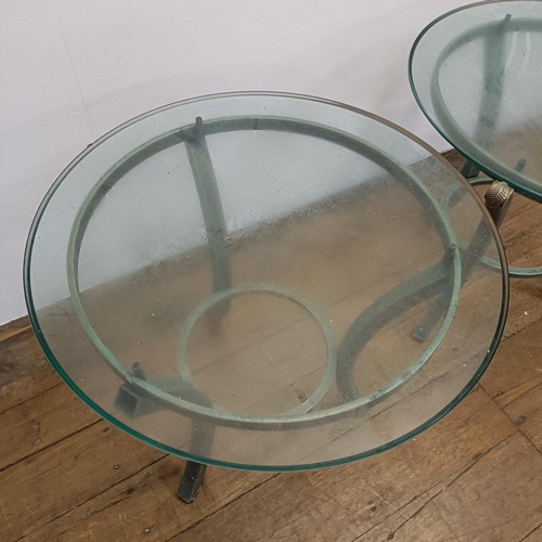 716 - A pair of glass top side tables, on metal bases, 60 cm diameter (2)