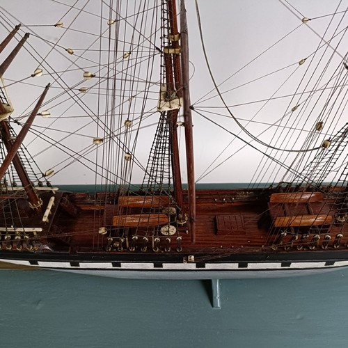 569 - A model of a three masted sailing ship, in a glass case, 74 cm wide