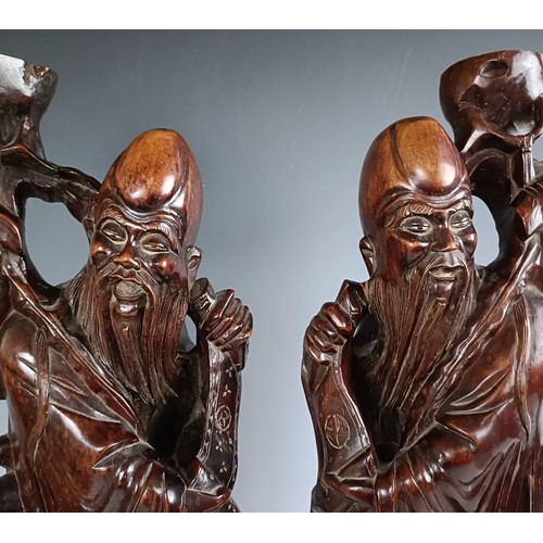 606 - A pair of Chinese carved figures, converted to lamp bases, 60 cm high (2)