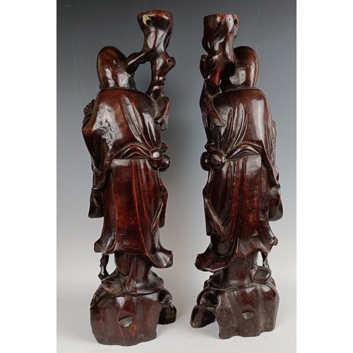 606 - A pair of Chinese carved figures, converted to lamp bases, 60 cm high (2)