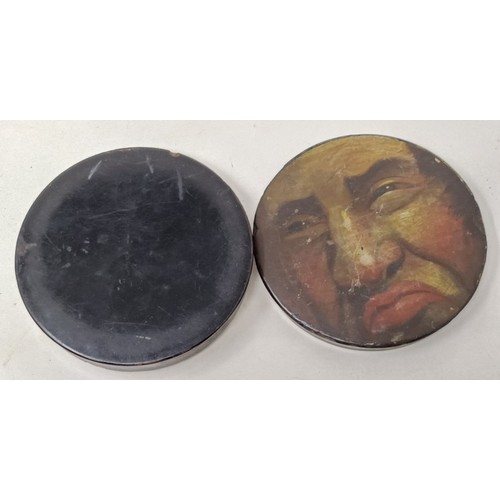 607 - A 19th century papier mache snuff box, the lid painted with face of a grotesque man, 11 cm diameter