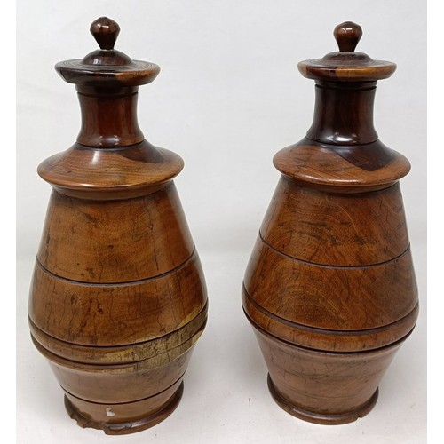 610 - A pair of turned lignum vitae urns and cover, 30 cm high (2)