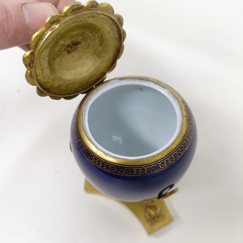 642 - A late 19th/early 20th century porcelain and gilt metal inkwell, 7 cm diameter