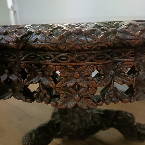 755 - A carved Burmese centre table, with a carved and pierced frieze, to a column support to a triangular... 