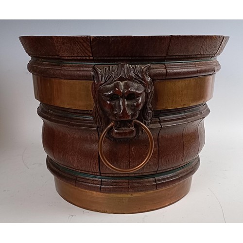 731 - An oak and brass bound jardinière, with lion's mask head handles, 33 cm diameter