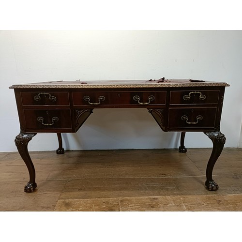 773 - A mahogany kneehole desk, having five drawers, flanked by faux drawers, on carved cabriole legs, and... 