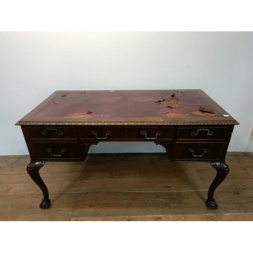 773 - A mahogany kneehole desk, having five drawers, flanked by faux drawers, on carved cabriole legs, and... 