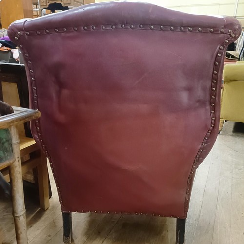 812 - A George III style leather wingback armchair, on carved cabriole legs to pad feet