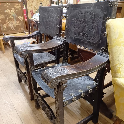 828 - A pair of Spanish oak and tooled leather armchairs (2)