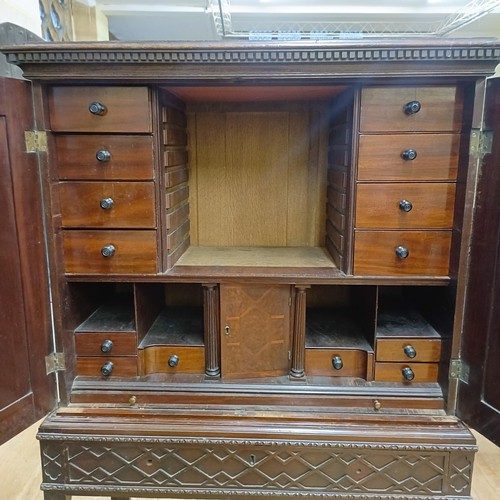 833 - An 18th century style walnut cabinet on stand, with two cupboard doors revealling a fitted interior,... 