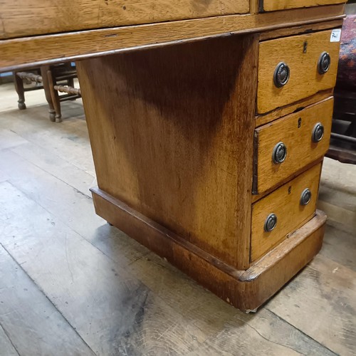 741 - An oak pedestal desk, having a nine drawer configuration, 120 cm wide