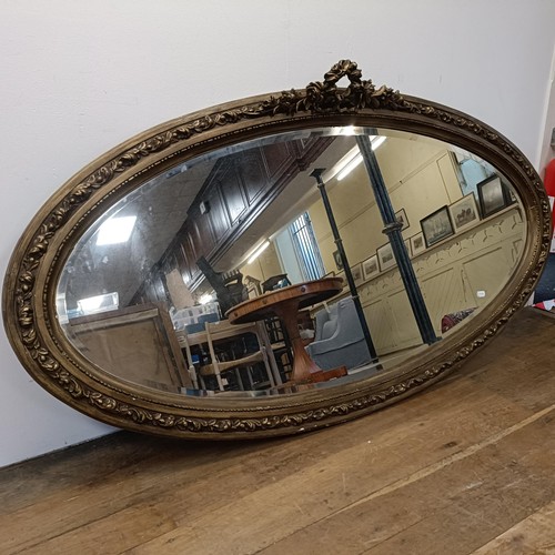 848 - A large gilt gesso oval mirror, 180 x 102 cm