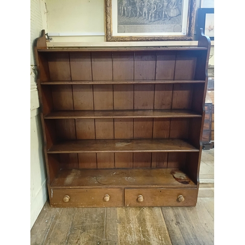 854 - A stained pine waterfall bookcase, the base with two drawers, 124 cm wide