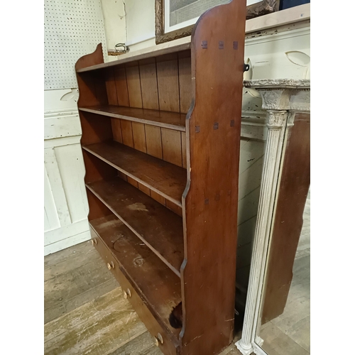 854 - A stained pine waterfall bookcase, the base with two drawers, 124 cm wide