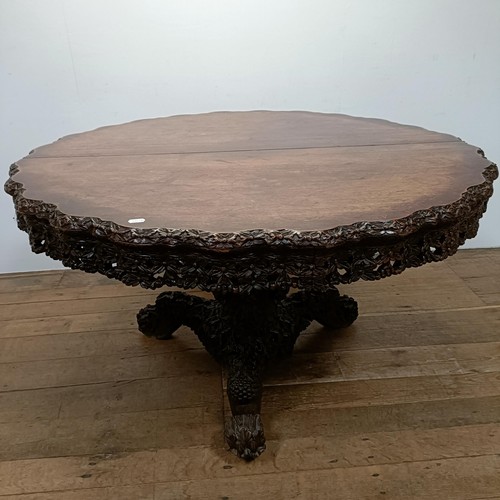 1254 - A Burmese centre table, with a carved and pierced frieze, to a column support to a triangular base a... 