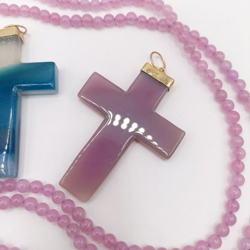 605 - A carved pink stone cross pendant, on a beaded necklace, and three carved hardstone crosses, with gi... 