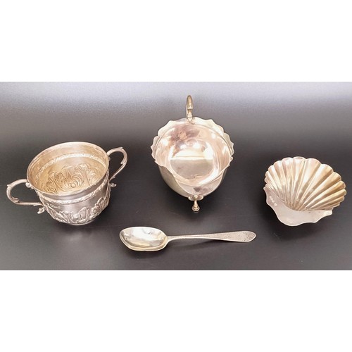 55 - A silver two handled cup, a sauce boat, a shell form dish, and a teaspoon, various dates and marks, ...