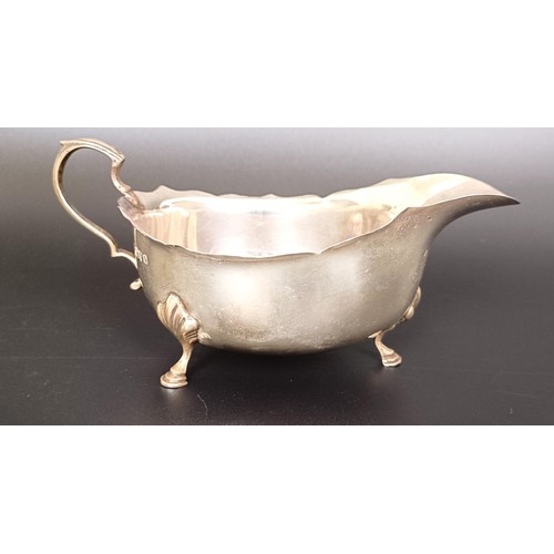 55 - A silver two handled cup, a sauce boat, a shell form dish, and a teaspoon, various dates and marks, ...