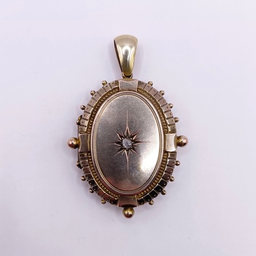 645 - A yellow metal and diamond oval locket