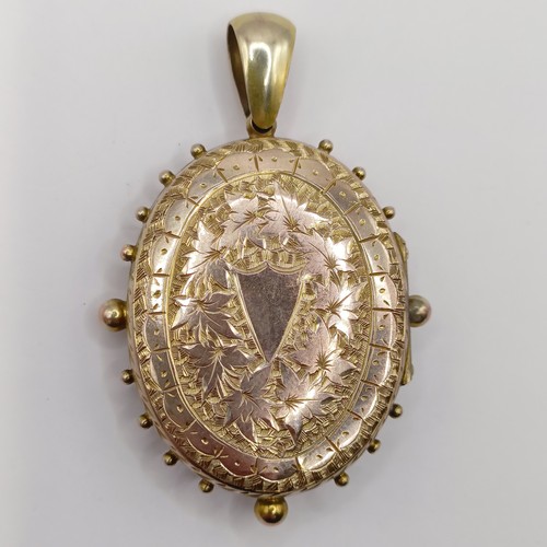 645 - A yellow metal and diamond oval locket