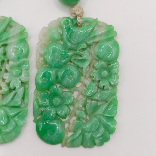 752 - A pair of Chinese carved greenstone pendants, 45 x 30 mm each