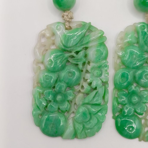 752 - A pair of Chinese carved greenstone pendants, 45 x 30 mm each