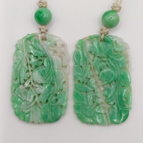 752 - A pair of Chinese carved greenstone pendants, 45 x 30 mm each