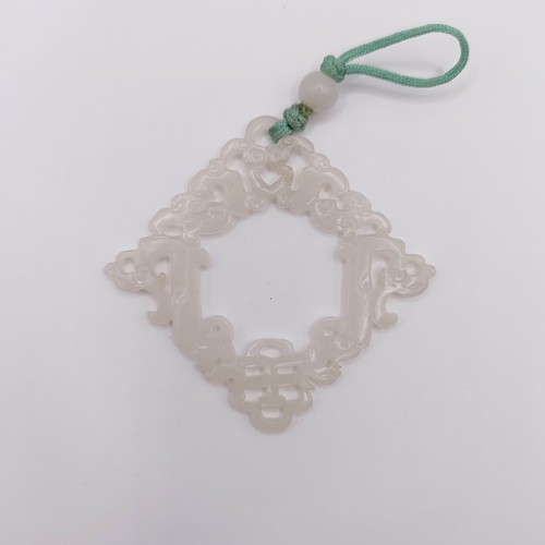 768 - A Chinese carved light stone pendant, approx. 70 x 70 mm