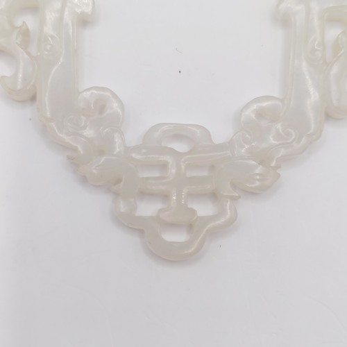 768 - A Chinese carved light stone pendant, approx. 70 x 70 mm