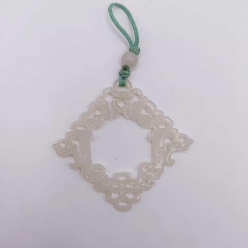 768 - A Chinese carved light stone pendant, approx. 70 x 70 mm