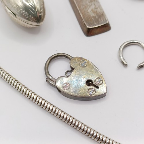 787 - An Eastern silver coloured metal fish pendant, a silver padlock bracelet clasp, a silver and red sto... 