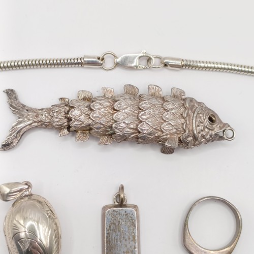 787 - An Eastern silver coloured metal fish pendant, a silver padlock bracelet clasp, a silver and red sto... 