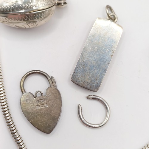 787 - An Eastern silver coloured metal fish pendant, a silver padlock bracelet clasp, a silver and red sto... 