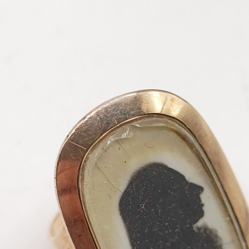 685 - A 19th century yellow metal plaque ring, inset with a silhouette portrait