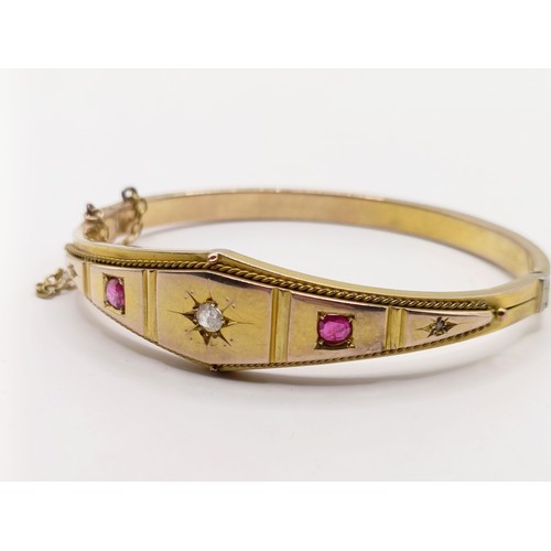 688 - A late 19th century yellow coloured metal, ruby and diamond bangle