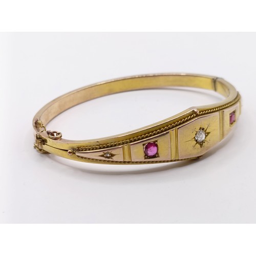 688 - A late 19th century yellow coloured metal, ruby and diamond bangle