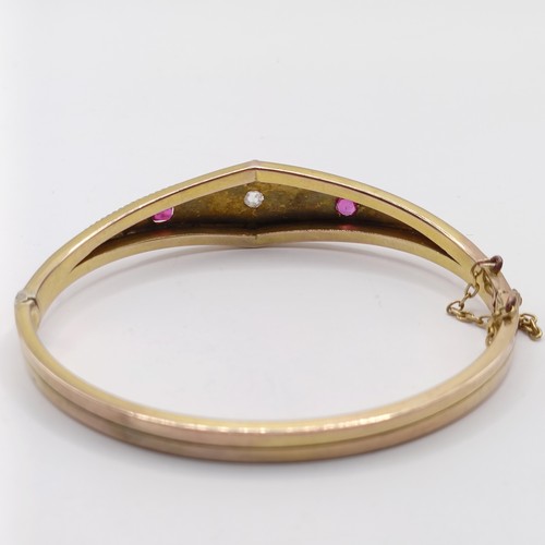 688 - A late 19th century yellow coloured metal, ruby and diamond bangle